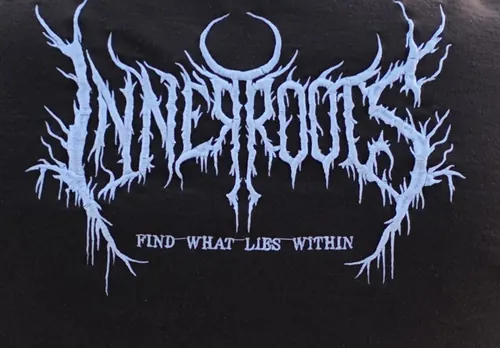 Close-up of the white Inner Roots Find What Lies Within logo embroidered on the back of a brown hoodie