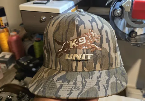 Camo cap with a K-9 Unit logo embroidered in white